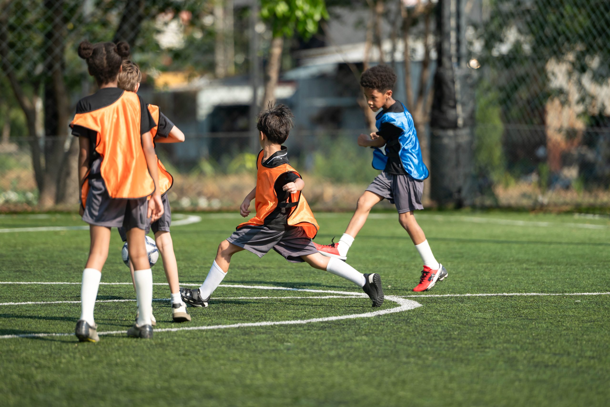 Enfants en plein match de football sur un terrain en plein air